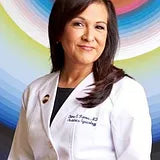 Professional headshot of a woman wearing a medical coat