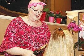photo of hair stylist curling clients long blond hair